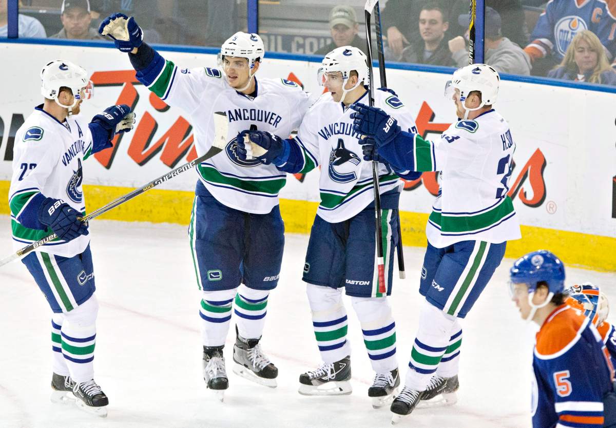 Vancouver Canucks' Daniel Sedin, Luca Sbisa, Radim Vrbata and Henrik Sedin celebrate a goal as Mark Fayne skates past during second period NHL hockey action in Edmonton, Alta., on Friday October 17, 2014. 