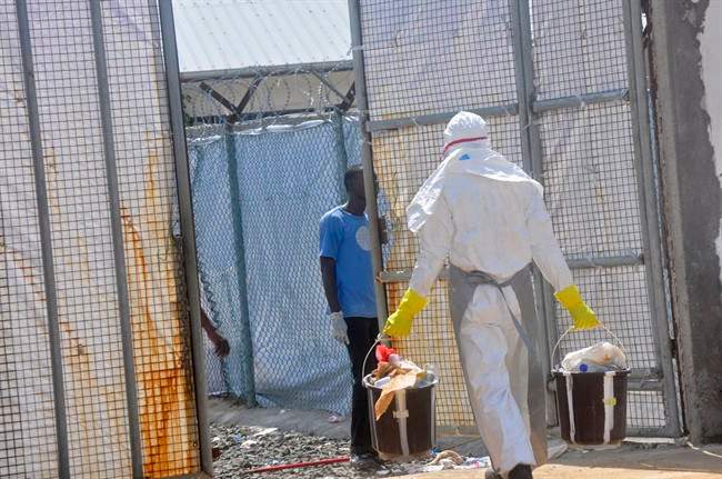 A Ebola health worker removes rubbish including plastic bottles from the Island Clinic Treatment center in Monrovia, Liberia, Wednesday, Oct. 29, 2014. 