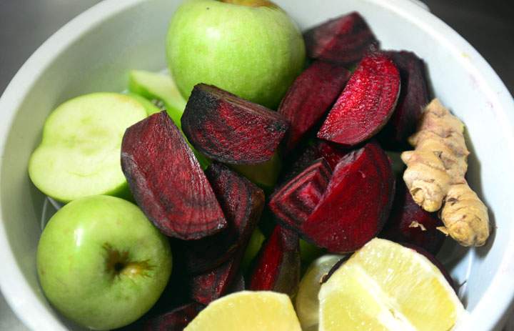 Green apples, beets, lemon and ginger are on display.