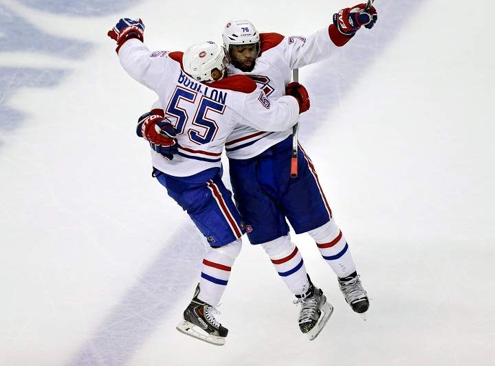 Montreal Canadiens defenseman Francis Bouillon (55) leaps into the arms of teammate P.K. Subban (76) during the third period of Game 1 in the second-round of the Stanley Cup playoff series in Boston, Thursday, May 1, 2014.