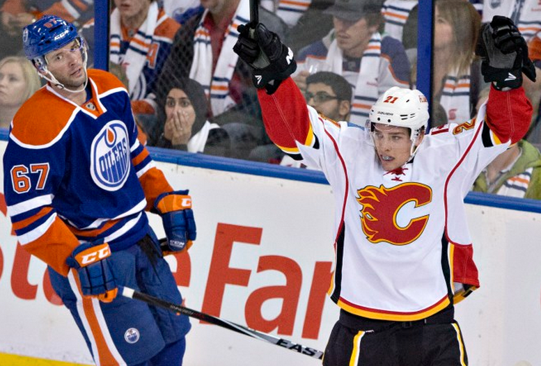 Calgary Flames' Mason Raymond celebrates a goal as Edmonton Oilers' Benoit Pouliot looks on during third period NHL hockey action in Edmonton, Alta., on Thursday October 9, 2014. (THE CANADIAN PRESS/Jason Franson).