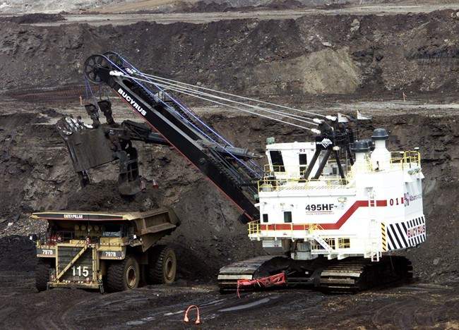 A hydraulic shovel loads a heavy hauler at an oilsands mine north of Fort McMurray, Alta. on June 19, 2003.