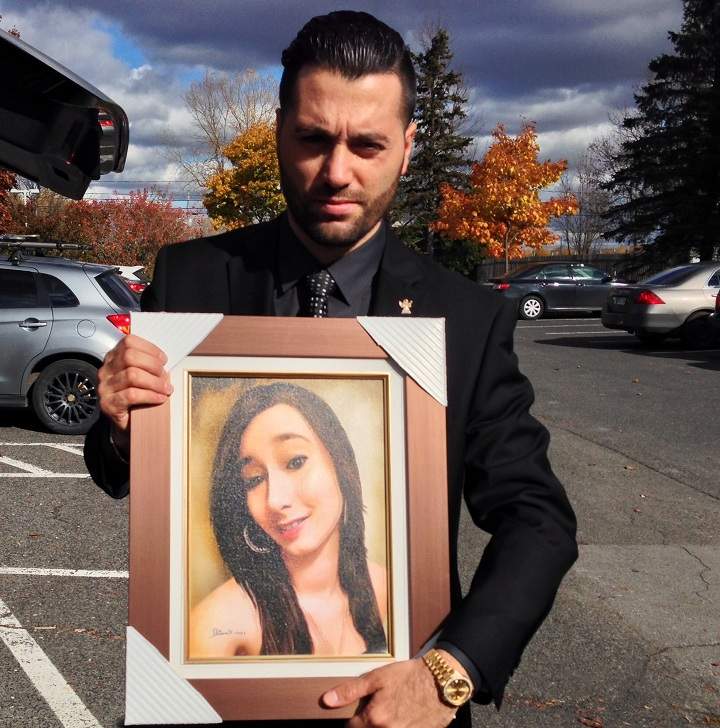 Dalcourt's brother holds a picture of her.