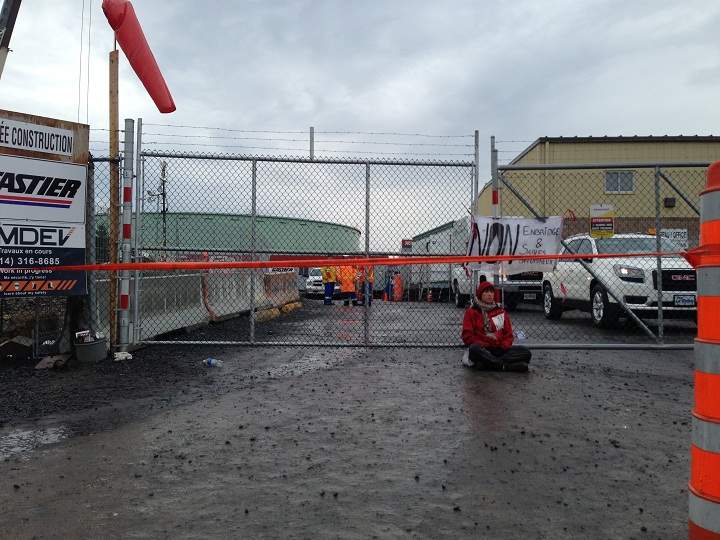 An activist chained with a bicycle u-lock and heavy chains to fences outside of an oil refinery in Montreal’s east end on October 7, 2014.