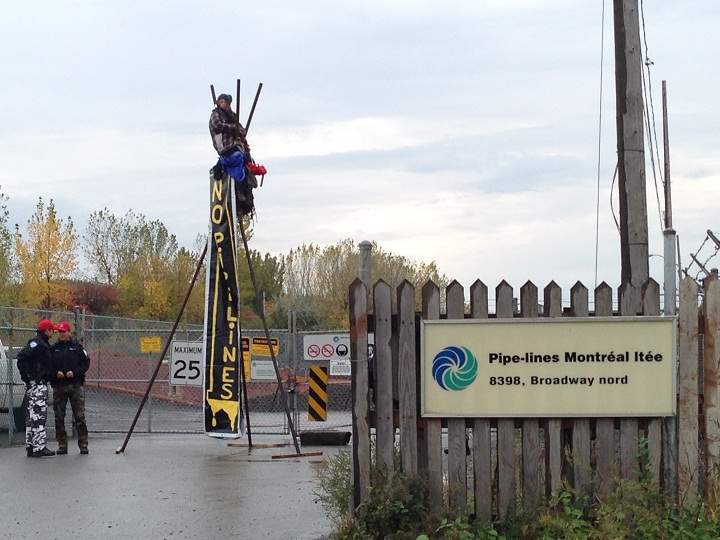 Police attempt to disassemble a tripod outside of an oil refinery in Montreal’s east end on October 7, 2014.