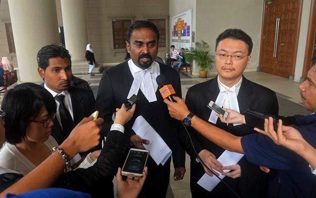 Malaysian lawyer Arunan Selvaraj, center, speaks to journalists outside a courthouse in Kuala Lumpur, Malaysia, Friday, Oct. 31, 2014. 