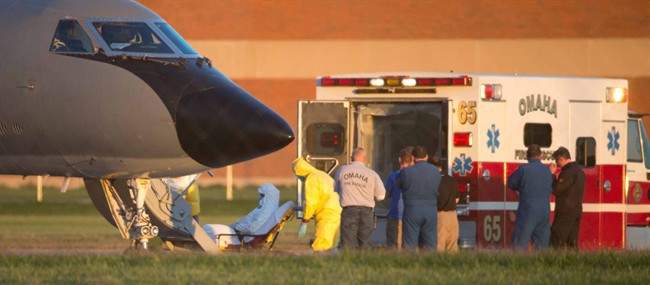 Ashoka Mukpo is loaded into an ambulance, Monday, Oct. 6, 2014, after arriving in Omaha, Neb. Mukpo, an American video journalist who contracted Ebola while working in Liberia, was taken to Nebraska Medical Center, where he will be treated for Ebola.