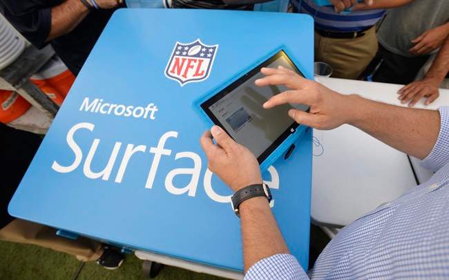 In this Aug. 3 2014 file photo, John Nisi, chief technology officer for Microsoft, works on a Surface tablet before the New York Giants play the Buffalo Bills at the Pro Football Hall of Fame exhibition NFL football game in Canton, Ohio.