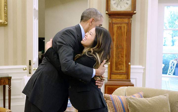 President Barack Obama gives a hug to Dallas nurse Nina Pham in the Oval Office of the White House October 24, 2014 in Washington, DC.