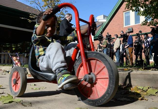 Youngsters play as NDP Leader Tom Mulcair holds a press conference at a daycare in Ottawa on Tuesday, October 14, 2014. The New Democrats are proposing a national child-care program that would cost no more than $15 a day per child. 