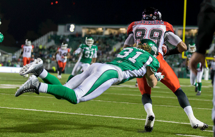 Samuel Hurl #31 of the Saskatchewan Roughriders makes a diving special teams tackle on Sederrik Cunningham #89 of the Calgary Stampeders in a game between the Calgary Stampeders and Saskatchewan Roughriders in week 15 of the 2014 CFL season at Mosaic Stadium on October 3, 2014 in Regina.