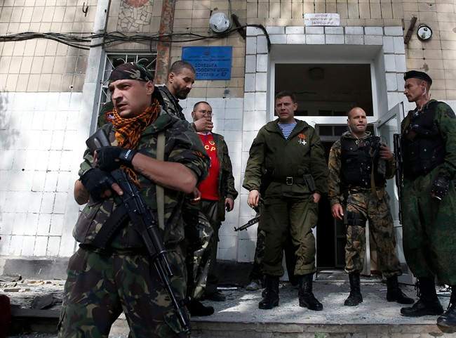 Alexander Zakharchenko, the leader of pro-Russian rebels in Donetsk, centre, observes the damage at a school after shelling in the town of Donetsk, eastern Ukraine, Wednesday, Oct. 1, 2014. 