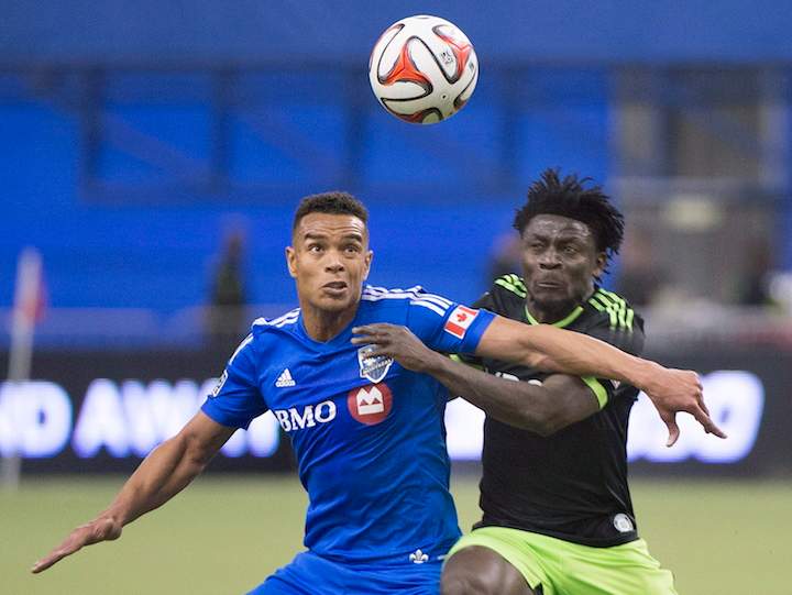 Montreal Impact's Matteo Ferrari, left, is challenged by Seattle Sounders' Obafemi Martins for the ball during second half MLS soccer action in Montreal, Sunday, March 23, 2014.