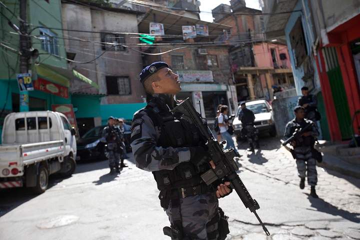 Police patrol in the Cantagalo slum ahead of a presidential run-off election in Rio de Janeiro, Brazil, Friday, Oct. 24, 2014.
