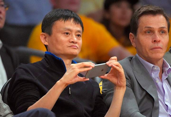 Jack Ma, left, executive chairman of Alibaba Group, watches the Los Angeles Lakers play the Houston Rockets during the first half of an NBA basketball game, Tuesday, Oct. 28, 2014, in Los Angeles.