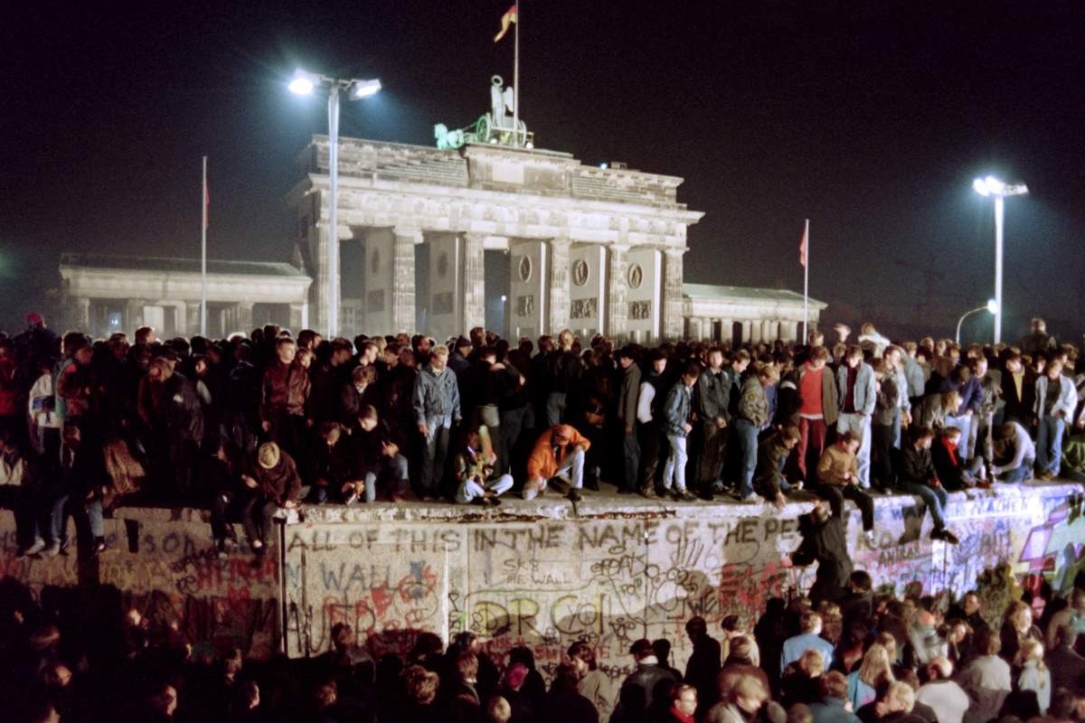 People dance on top of the Berlin Wall
