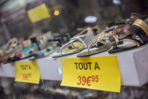 Euro price signs sit beneath a display of women's sandals in a footwear store in Toulouse, France, on Tuesday, Aug. 12, 2014.