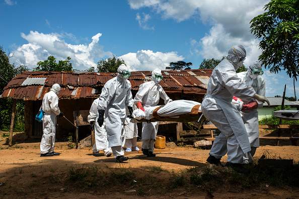 A body is carried to the back of a pickup truck by a county health burial team on Friday November 7, 2014 in Voinjama, Liberia. 