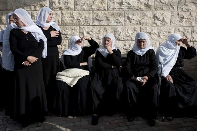 Druze women mourn during the funeral of Druze Israeli police officer Zidan Sif in the Druze village of Yanuh-Jat, northern Israel, Wednesday, Nov. 19, 2014. 