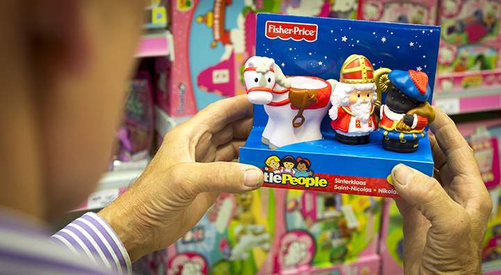 A man holds a box containing Sinterklaas (Saint Nicolas) and Zwarte Piet (Black Pete) toy dolls, made by toy manufacturer Fisher-Price in a store in Amsterdam on September 8, 2014.