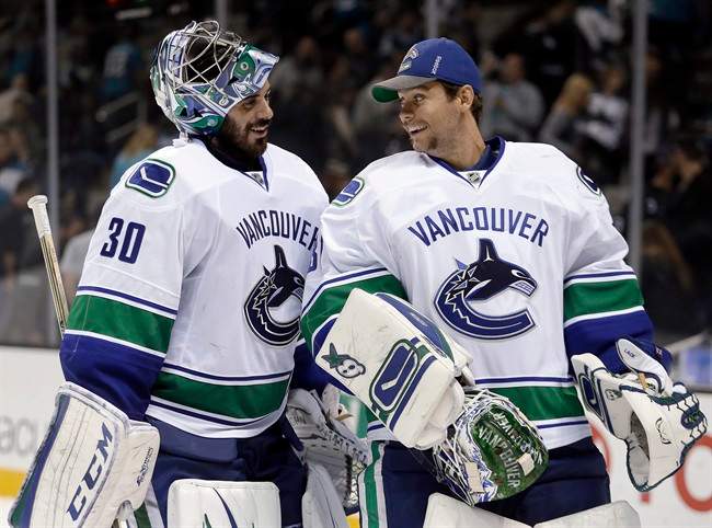 Vancouver Canucks goalies Ryan Miller, left, and Eddie Lack smile at the end of an NHL hockey game against the San Jose Sharks on Thursday, Nov. 6, 2014, in San Jose, Calif. Vancouver won 3-2.