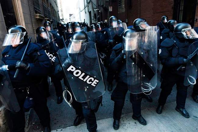 Riots police get ready to deploy as activists and protesters march along the streets of downtown Toronto during the G8/G20 Summits on Friday, June 25, 2010.
