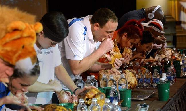 In this Nov. 22, 2014 photo, Joey Chestnut, center, and the other eaters participate in the World Turkey-Eating Championship at Foxwoods Resort and Casino in Mashantucket, Conn.