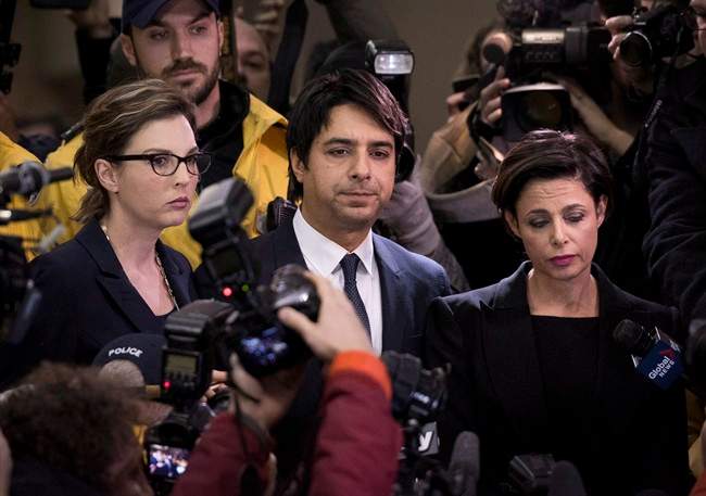 Jian Ghomeshi makes his way through a mob of media with his lawyer Marie Henein (right) at a Toronto court Wednesday, November 26, 2014.