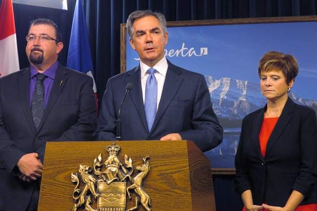 Alberta Premier Jim Prentice (centre) announces Monday, Nov.24, 2014 at legislature in Edmonton that opposition Wildrose members Ian Donovan, left, and Kerry Towle, right, have crossed the floor to join his Progressive Conservative caucus. 