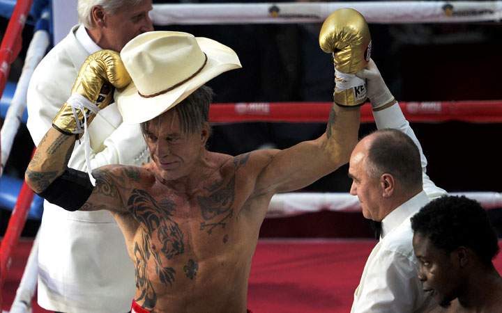 A referee holds up Hollywood actor Mickey Rourke's (L) fist, 62, after he knocked out US professional Elliot Seymour (R), 29, in Moscow on November 28, 2014, as Rourke revives his boxing career at the age of 62 taking to the ring.