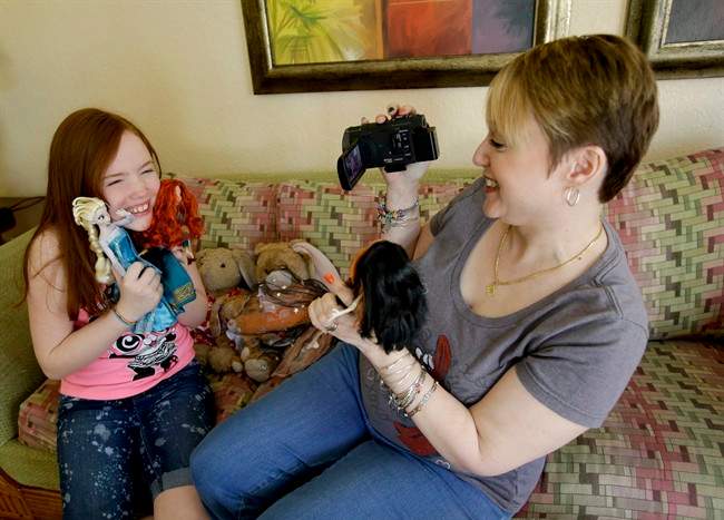 Gracie Hunter, left, and her Mom, Melissa make a video for a doll review while on vacation in Kissimmee, Fla. The mother-daughter duo, stars of the "Mommy and Gracie" YouTube show, review dolls for kids.