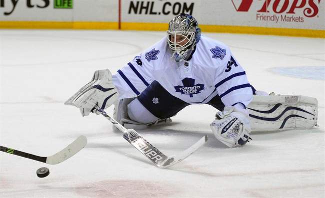 Toronto Maple Leafs goaltender James Reimer tries to poke check the puck shot by Buffalo Sabres center Brian Flynn during the first period of an NHL hockey game Saturday, Nov. 15, 2014, in Buffalo, N.Y.