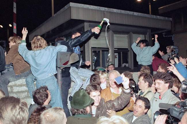 In this Nov. 10, 1989, file photo, East and West Berliners mingle as they celebrate in front of a control station on East Berlin territory, during the opening of the borders to the West following the announcement by the East German government that the border to the West would be open. 