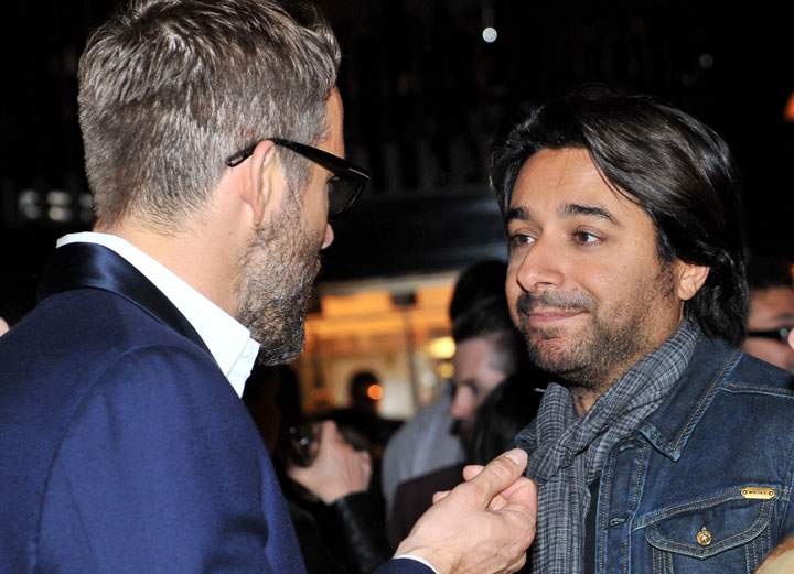 Jian Ghomeshi, right, talks to Ryan Reynolds at a party during the 2014 Toronto International Film Festival.
