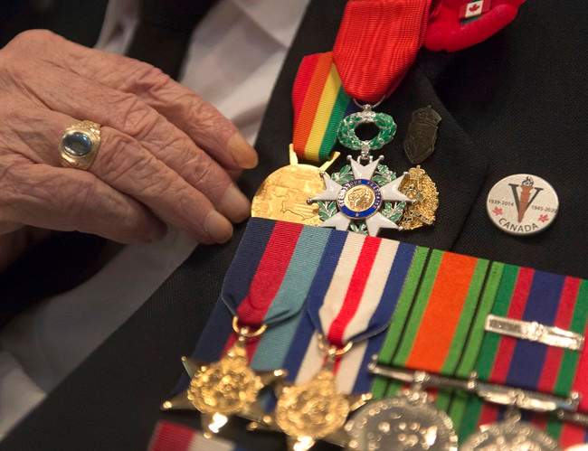 A veteran adjusts his medals in this 2014 file photo. Officials are hoping the province's new pilot project can help support veterans who end up in contact with the justice system.