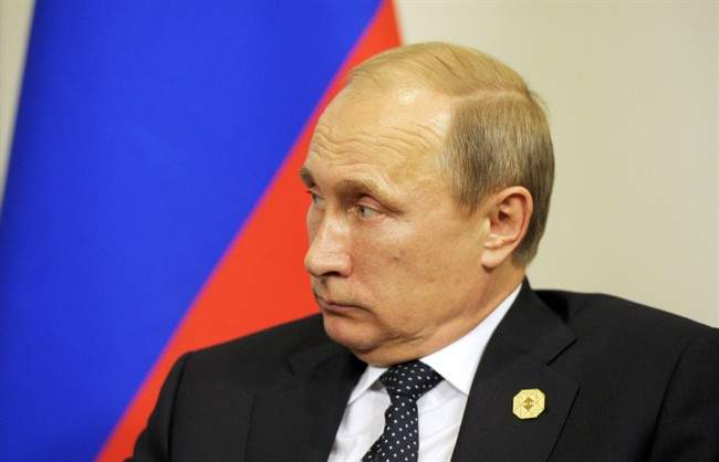Russia's President Vladimir Putin looks over at the French president during their bilateral meeting on the sidelines of the G20 Summit in Brisbane, Australia, Saturday, Nov. 15, 2014.