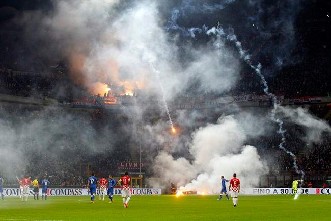 Flares are launched by Croatia supporters during the Euro 2016 qualifying soccer match between Italy and Croatia, at the San Siro stadium in Milan, Italy, Sunday, Nov. 16, 2014. 