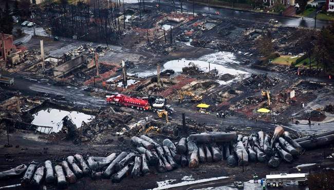 Workers comb through debris after a train derailed Saturday, July 9, 2013 causing explosions of railway cars carrying crude oil in Lac-Megantic, Que.
