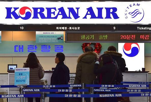 Travelers are seen at the Korean Air ticketing desk at Gimpo airport in Seoul on December 16, 2014. 