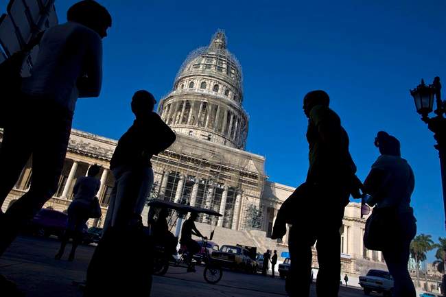 People line up to take the bus outside the Capitolio in Havana, Cuba, Thursday, Dec. 18, 2014. 