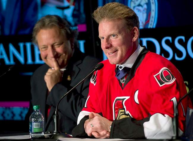Ottawa Senators owner Eugene Melnyk looks on as Daniel Alfredsson responds to a question during a news conference after signing a one day contract Thursday December 4, 2014 in Ottawa.