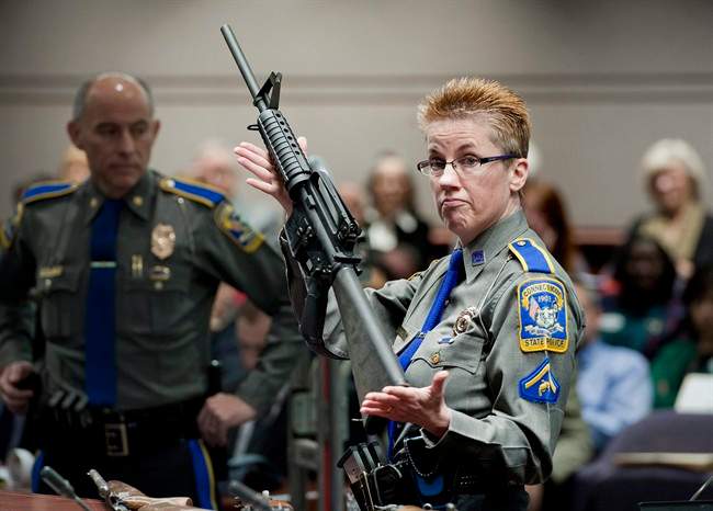 In this Jan. 28, 2013, file photo, firearms training unit Detective Barbara J. Mattson, of the Connecticut State Police, holds up a Bushmaster AR-15 rifle, the same make and model of gun used by Adam Lanza in the Sandy Hook School shooting.