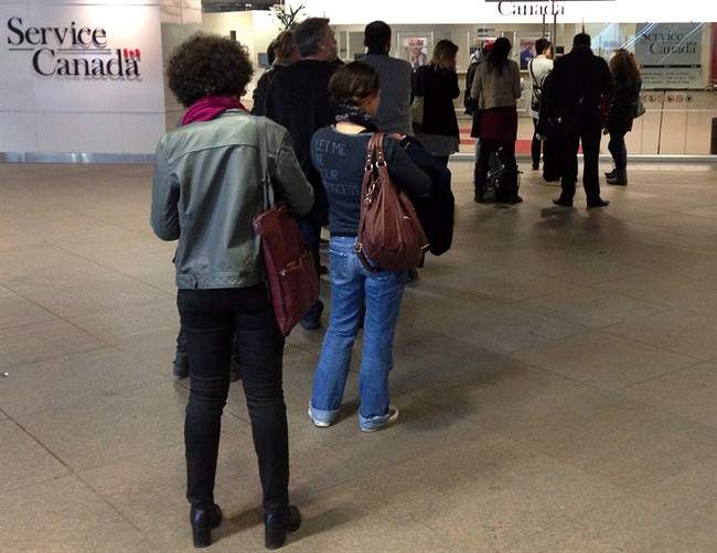 People wait for the Service Canada centre to open on April 2, 2014 in Montreal.