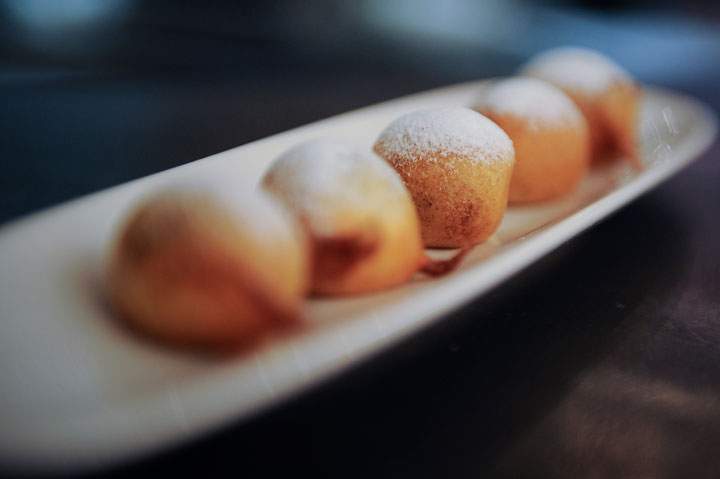 Chocolate fritters dusted with icing sugar are pictured.