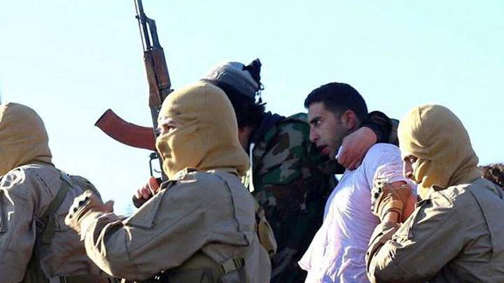 This image posted by the Raqqa Media Center of the Islamic State group, a militant extremist group, which has been authenticated based on its contents and other AP reporting, shows members of the Islamic State group with a captured pilot, center, wearing a white shirt in Raqqa, Syria, Wednesday, Dec. 24, 2014. Activists say that Islamic State fighters have shot down a warplane believed to be from the U.S.-led coalition over Syria.