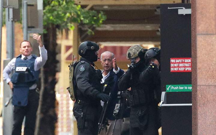 A hostage runs to safety outside the Lindt Cafe, Martin Place on December 15, 2014 in Sydney, Australia.