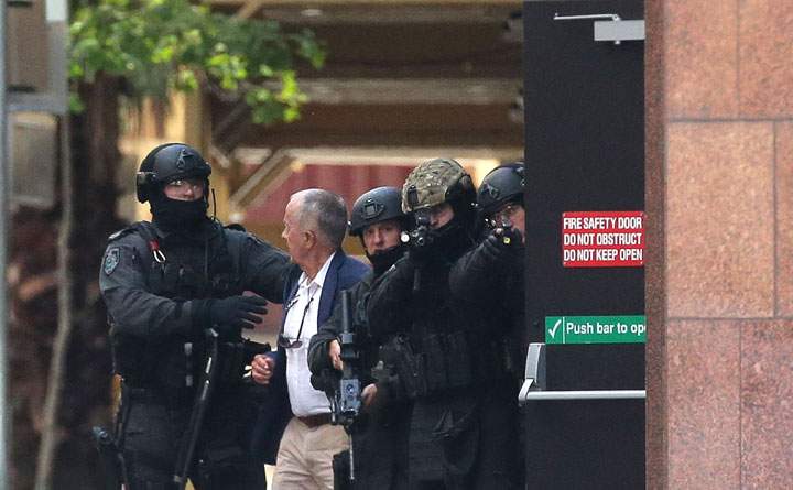 A hostage runs to safety outside the Lindt Cafe, Martin Place on December 15, 2014 in Sydney, Australia.