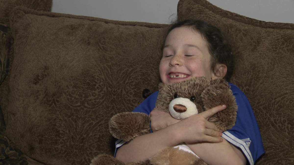 Lyttle wearing her signed Brett Lawrie jersey and holding her Blue Jays teddy bear.