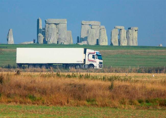 This is an undated handout photo issued by the National Trust, via the Press Associated of a truck passing Stonehenge on the A303 road in Wiltshire England. (AP Photo/John Miller/National Trust/PA).