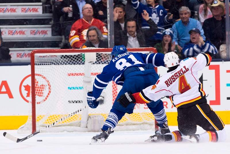Toronto Maple Leafs forward Phil Kessel (81) fights off Calgary Flames defenceman Kris Russell (4) to score a empty net goal during third period NHL hockey action in Toronto on Tuesday, December 9, 2014. 